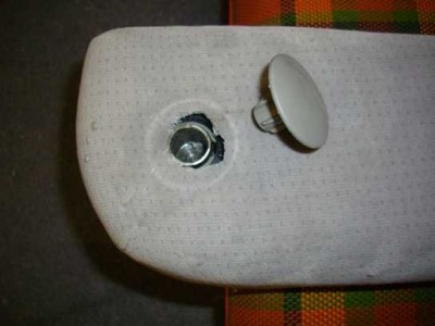Zum Abziehen des Stoffes den Abdeckknopf am Ende der Achswelle vorsichtig aushebeln. Armlehne ist hier mit einem Sprengring auf der Welle gesichert.